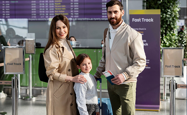 Happy family at airport with luggage assisted by immigration consultants in Kerala
